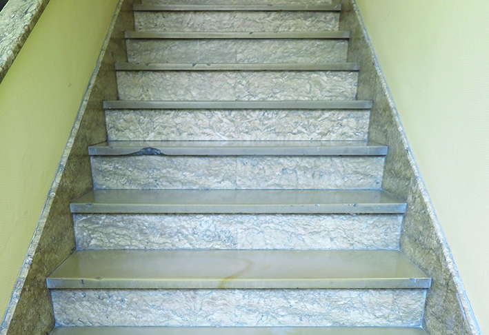 Posadzka na klatce schodowej w budynku przy ul. Abrahama 37. Płyty z wapienia mikrytowego, podstopnice i cokoły schod&oacute;w z okładziny marmurowej, prawdopodobnie importowanej