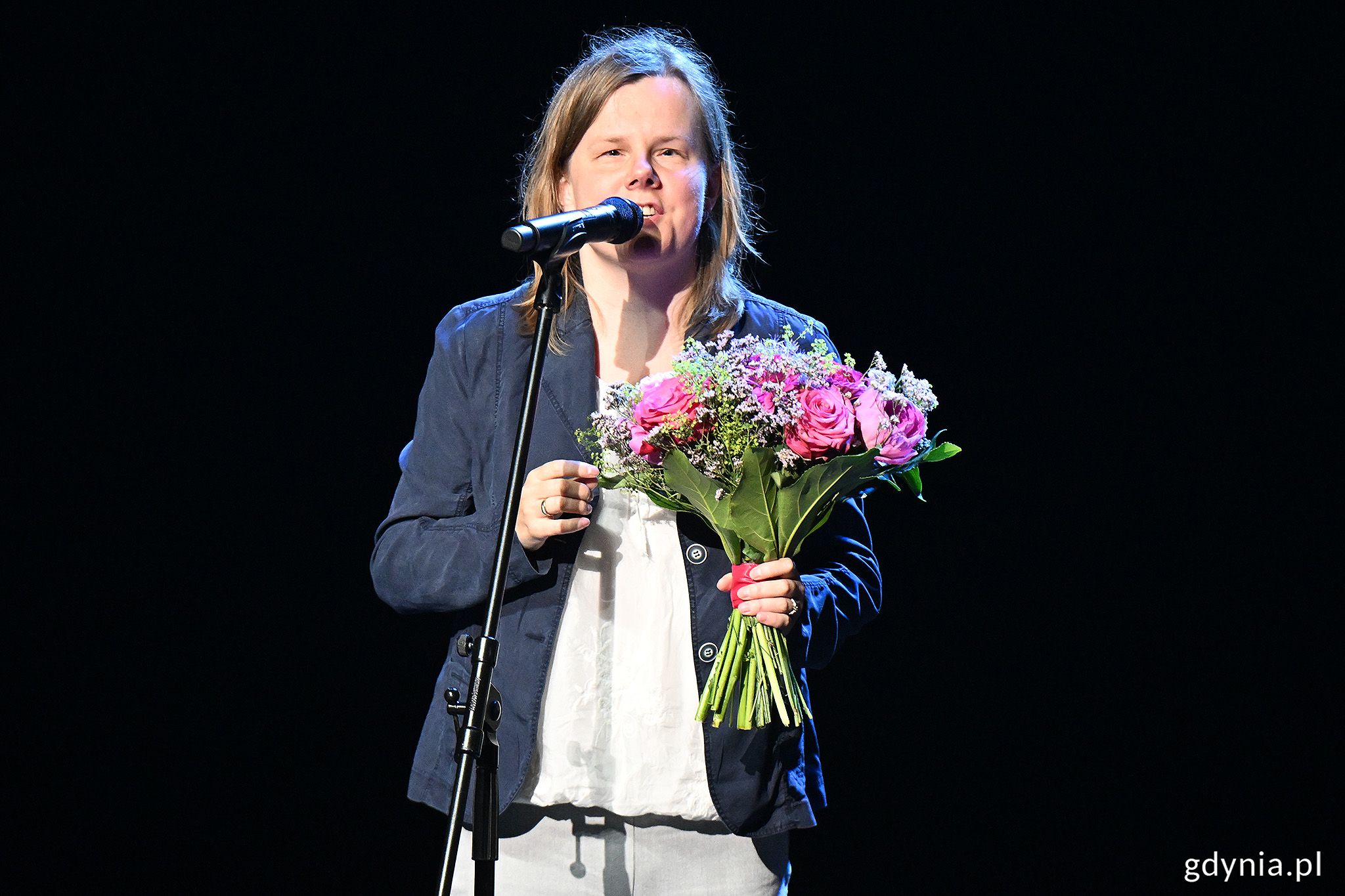 Izabela Dłużyk na scenie z kwiatami podczas gali Gdynia bez barier