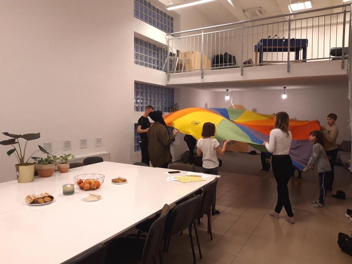 dzieci bawiące się kolorowym latawcem