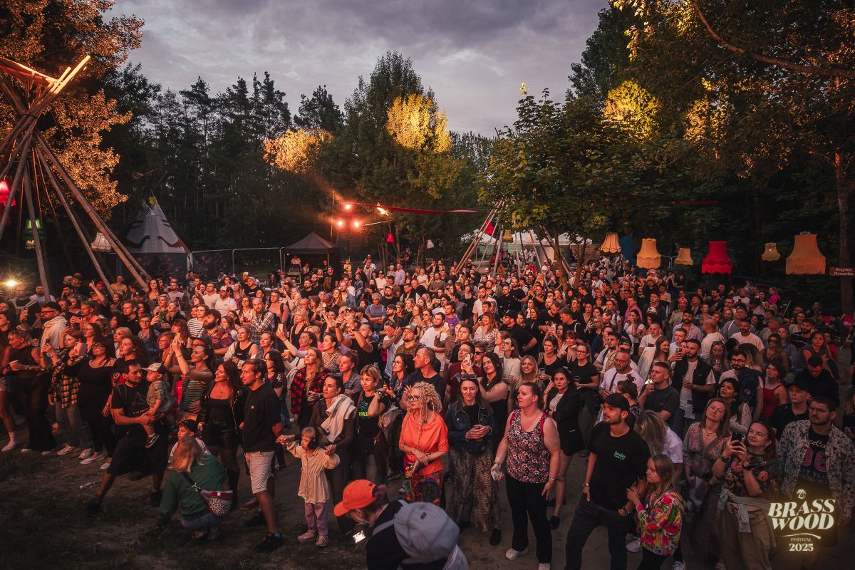 Grupa uczestnik&oacute;w festiwalu w Parku Kolibki, podczas występu artyst&oacute;w.