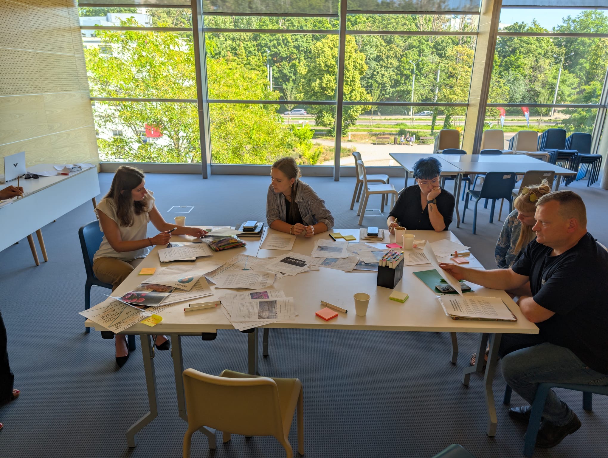 Ludzie przy wsp&oacute;lnym stole na warsztatach projektu Furkan 