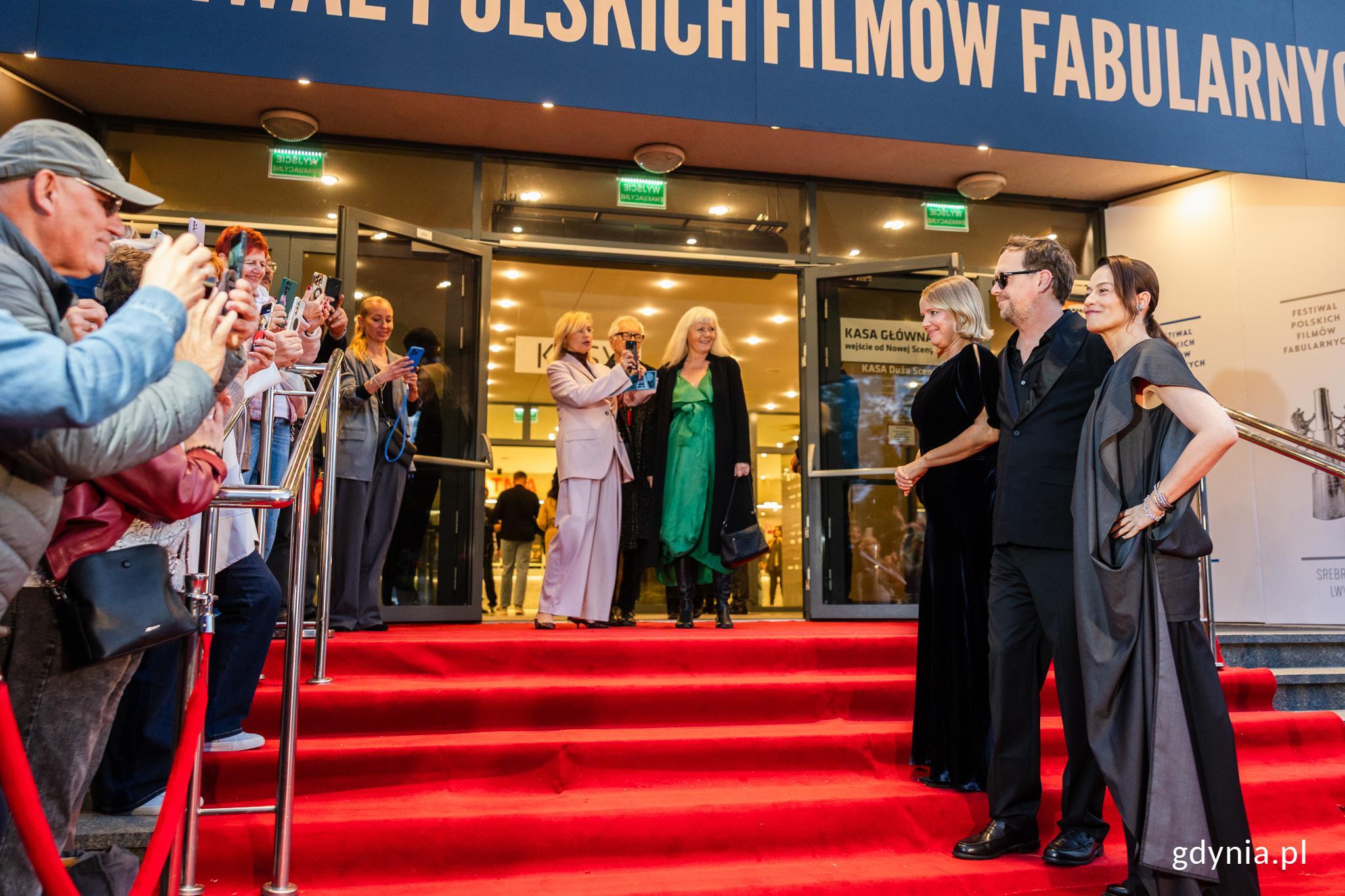 Wejście do Teatru Muzycznego, czerwony dywan, aktorzy pozują do zdjęć przed tłumem