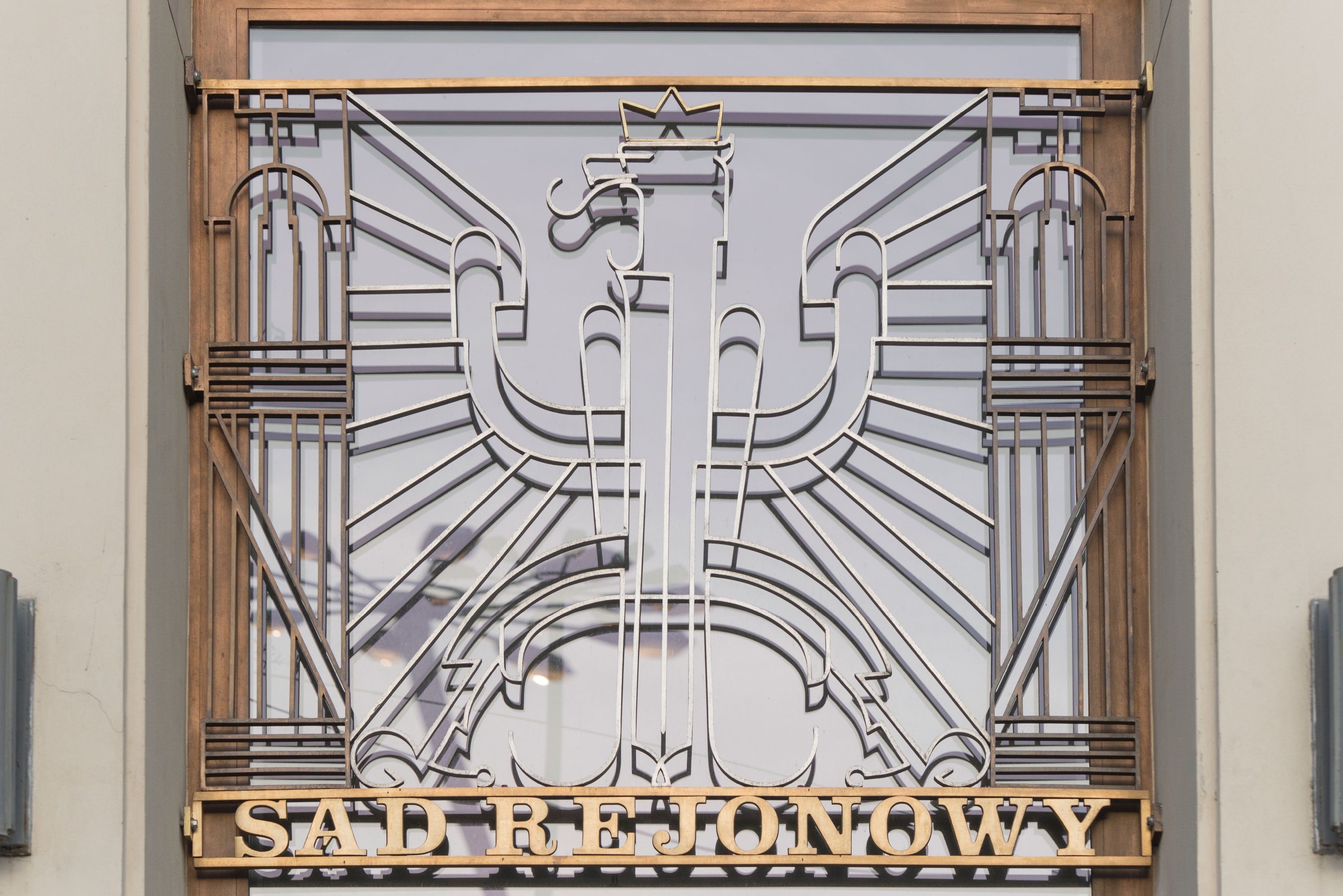 Wejście gł&oacute;wne do Sądu Rejonowego z lat 30. XX w. przy placu Konstytucji, ozdobione dekoracją plastyczną z godłem, wykonaną z mosiężnych i aluminiowych płaskownik&oacute;w