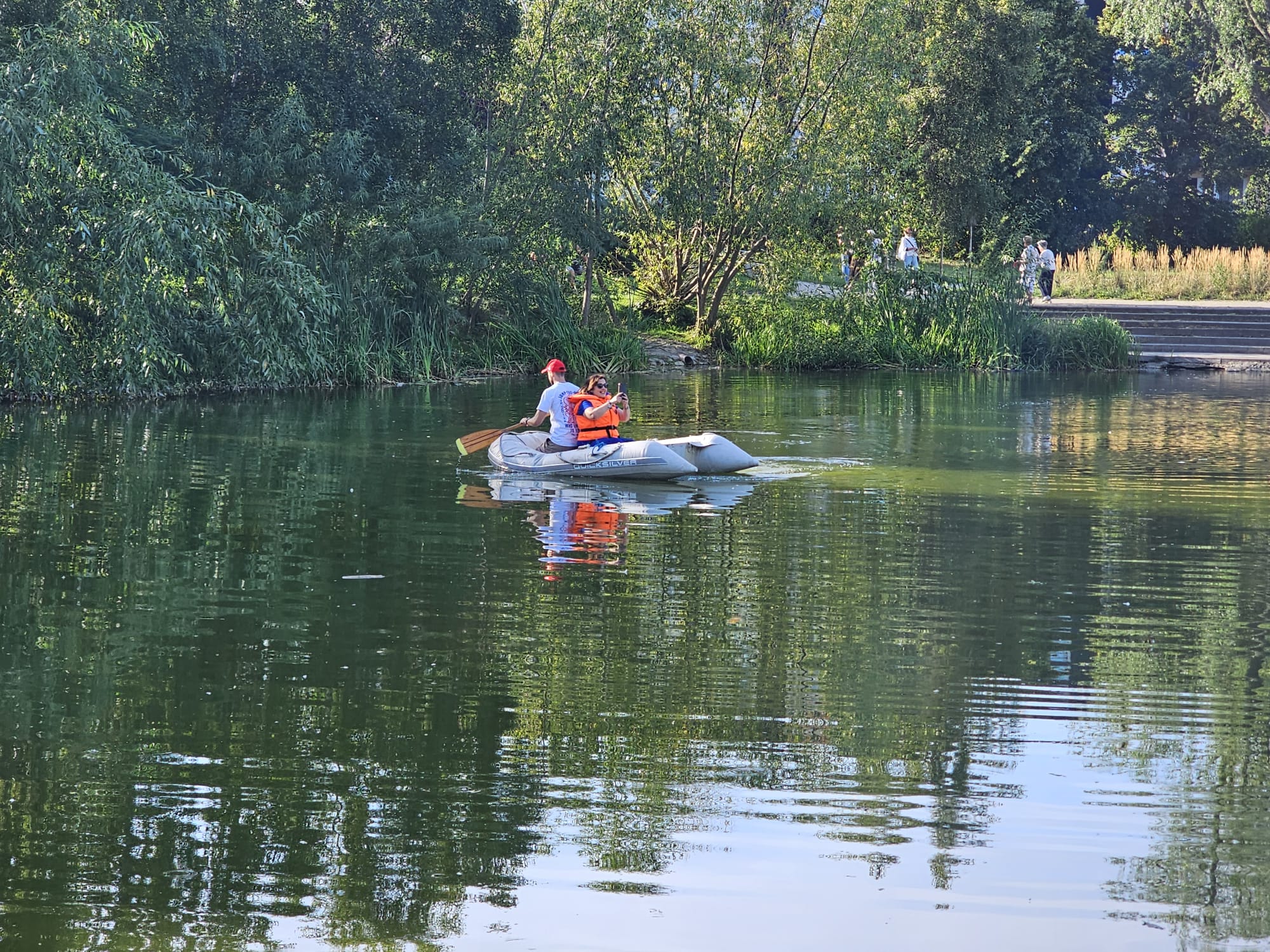 Na pontonie na stawie pływają dwie osoby