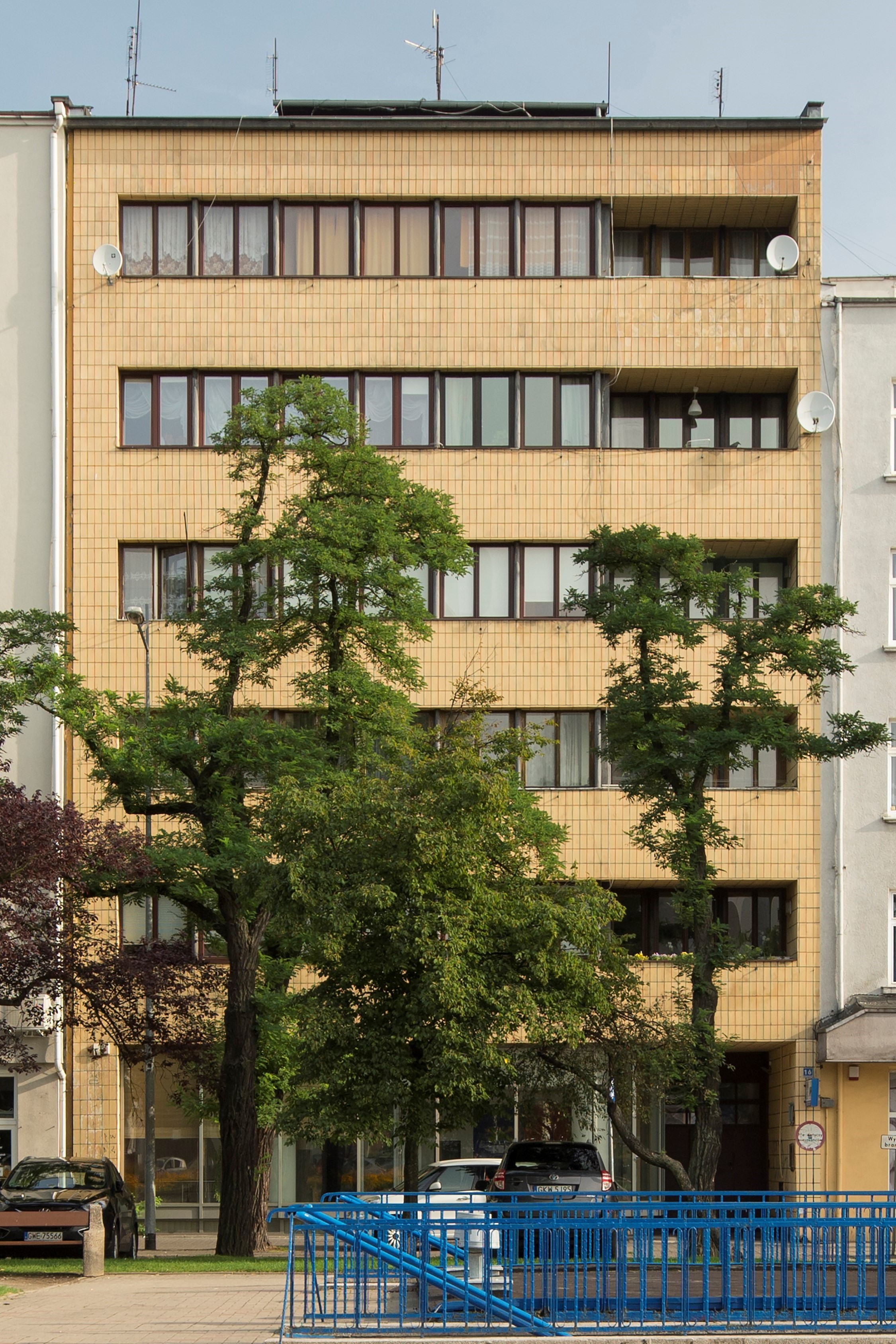 Kamienica przy skwerze Kościuszki 16, ż&oacute;łtymi płytkami oblicowano całą płaszczyznę elewacji.