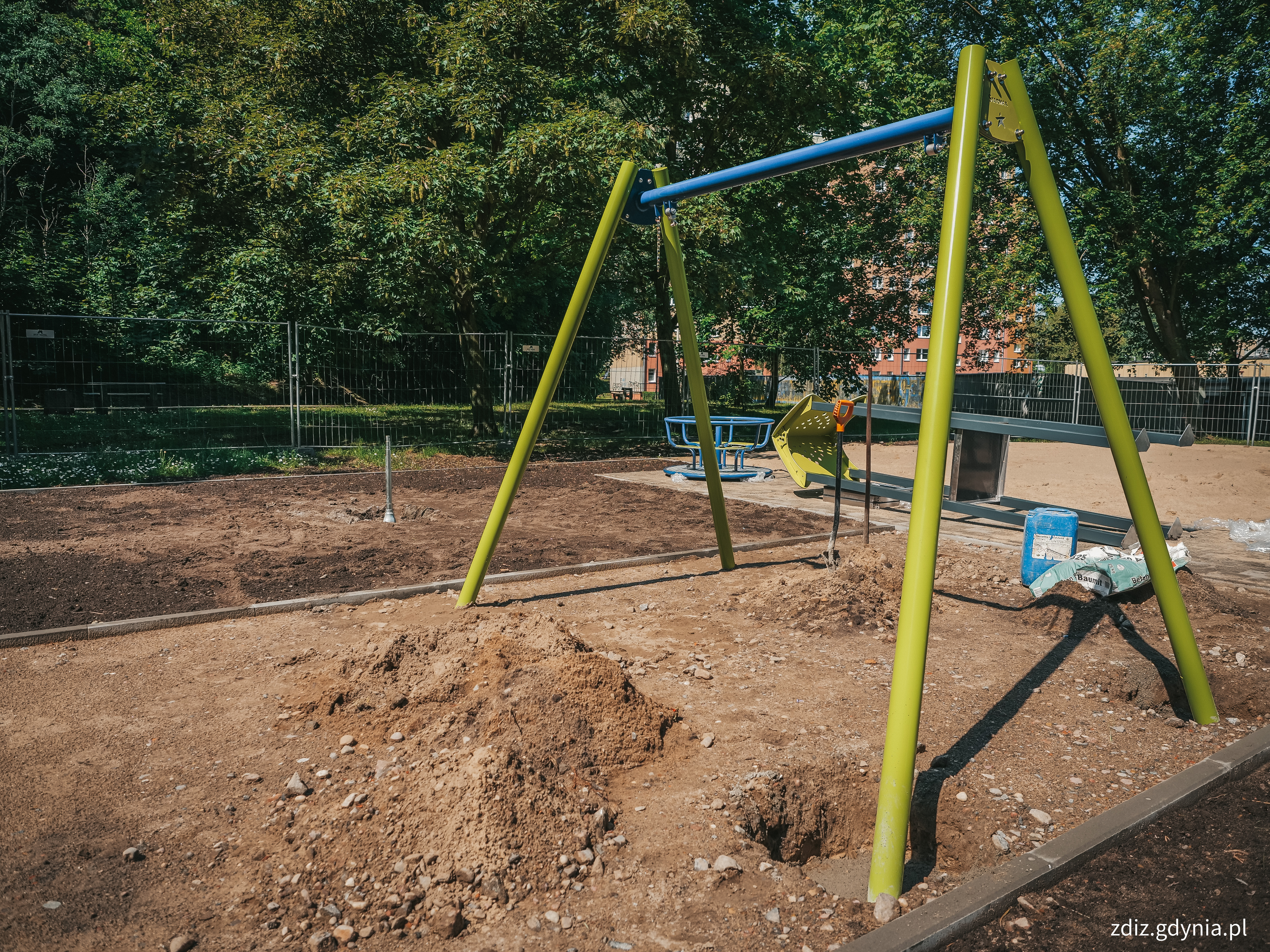 widok na remontowany plac zabaw, na pierwszym planie huśtawka
