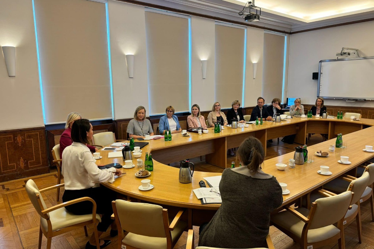 Grupa ludzi siedzących przy stołach podczas spotkania