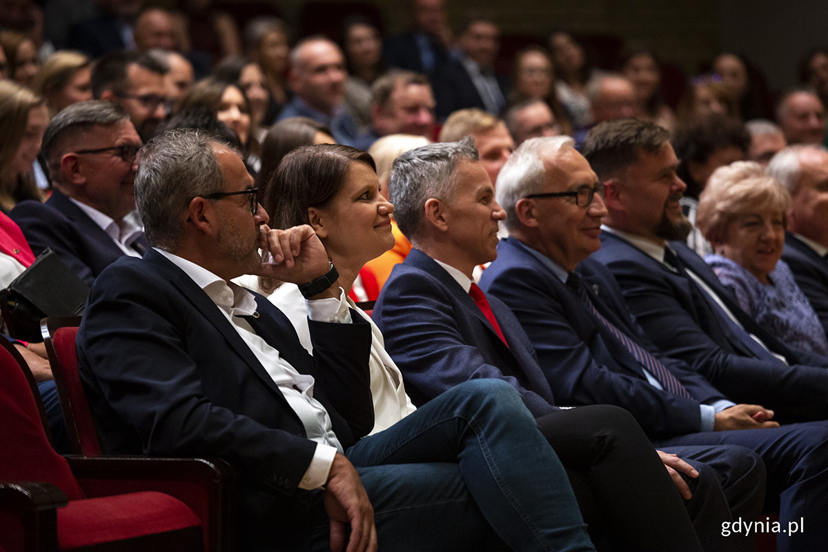 Publiczność siedzi na sali koncertowej.