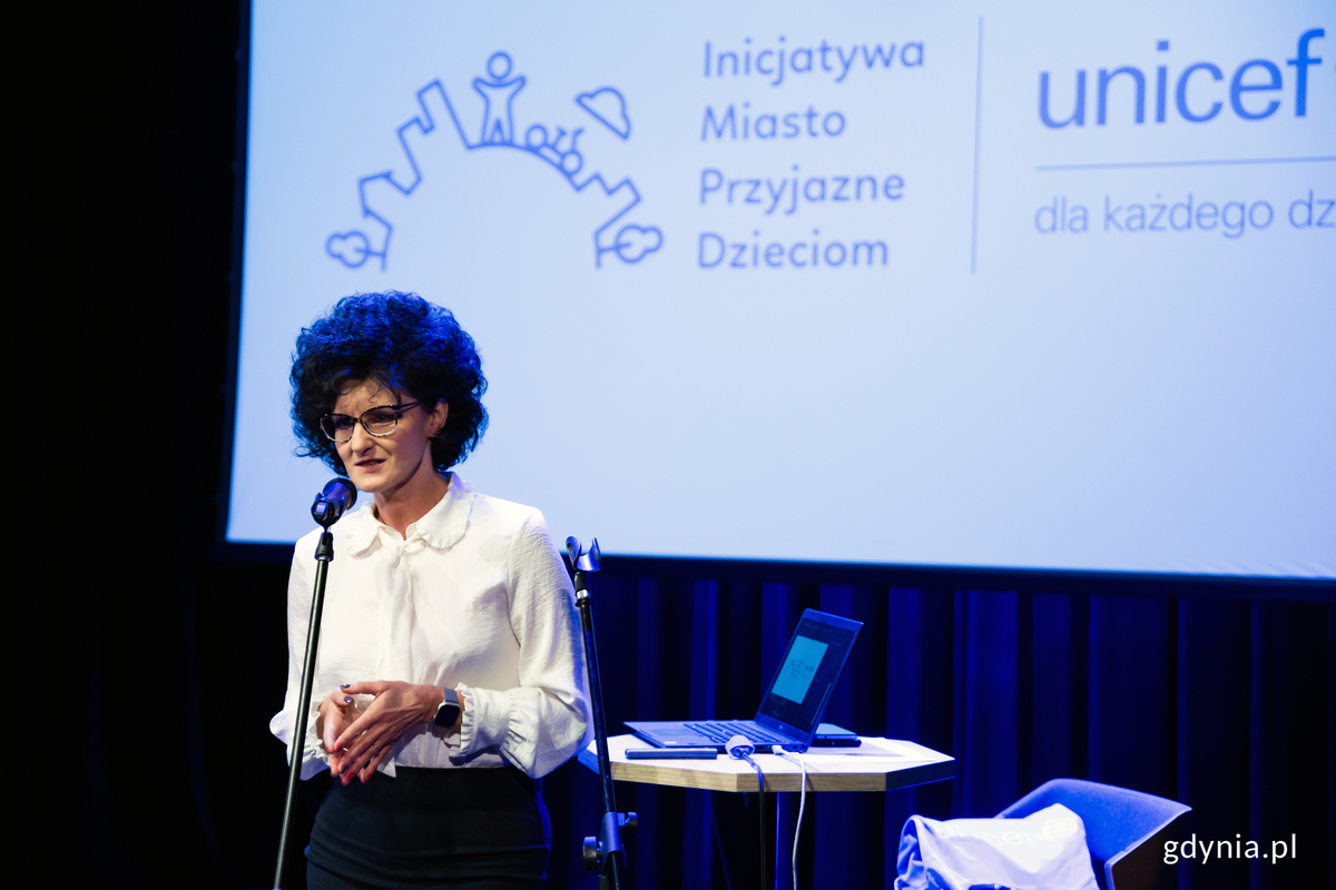 Kobieta przemawia na m&oacute;wnicy.