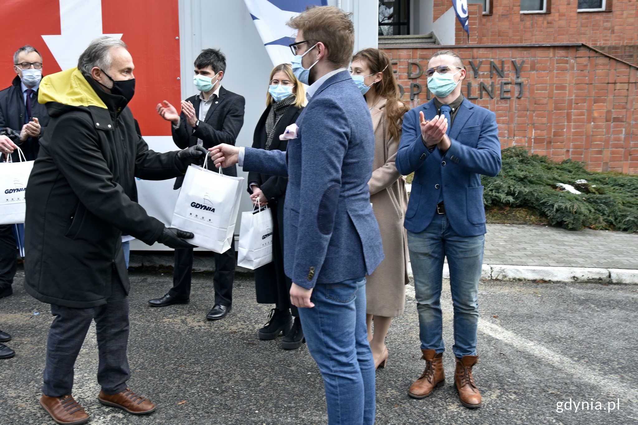 Prezydent Gdyni Wojciech Szczurek wręcza dyplom i drobne upominki jednemu ze student&oacute;w Gdańskiego Centrum Medycznego, kt&oacute;ry pracuje w centrum testowym Covid-19 drive-thru przy IMMiT // fot. Magdalena Czernek