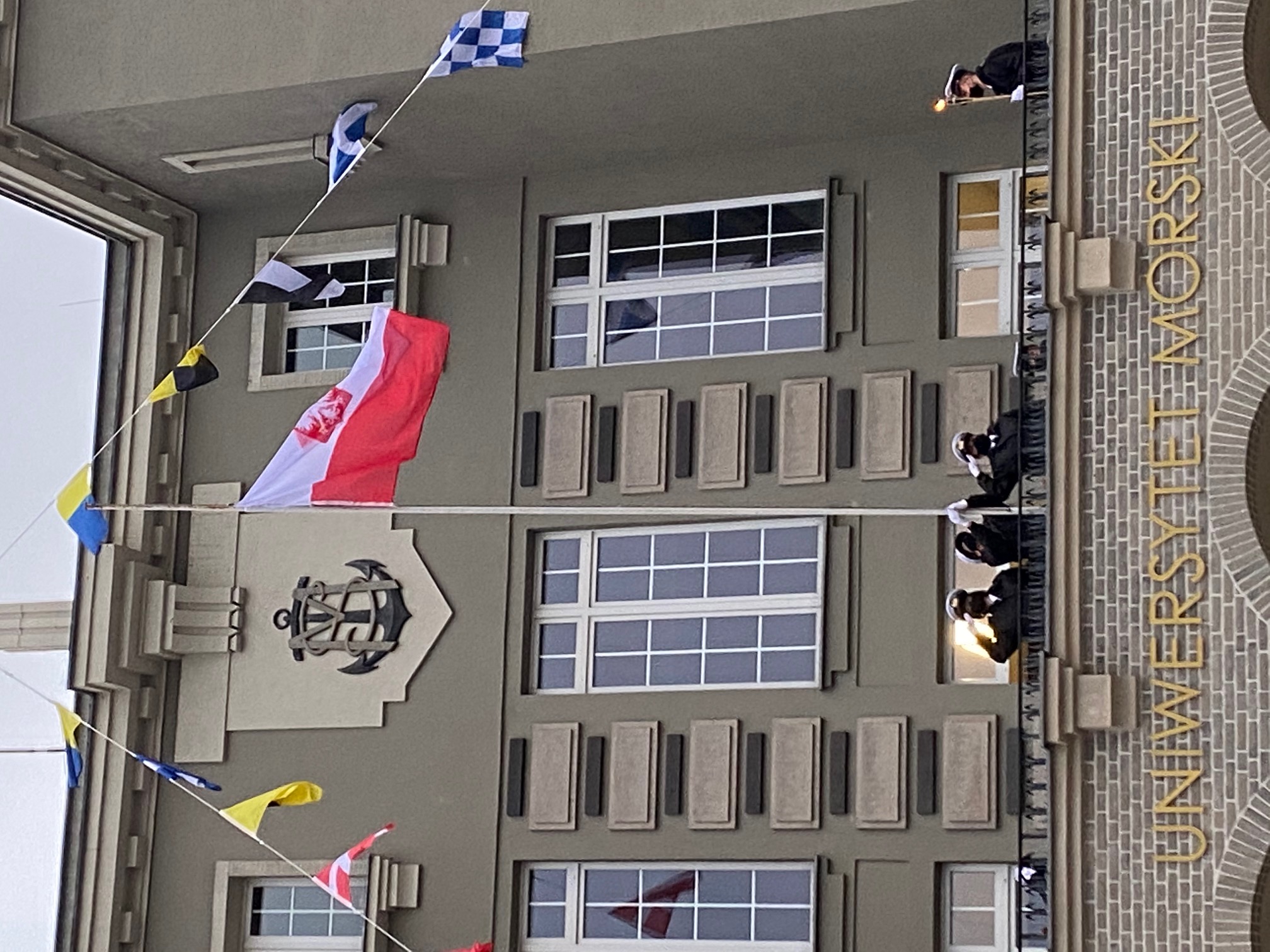 Biało-czerwona bandera wciągana na maszt przez student&oacute;w Uniwersytetu Morskiego z okazji stulecia uczelni // fot. Uniwersytet Morski w Gdyni