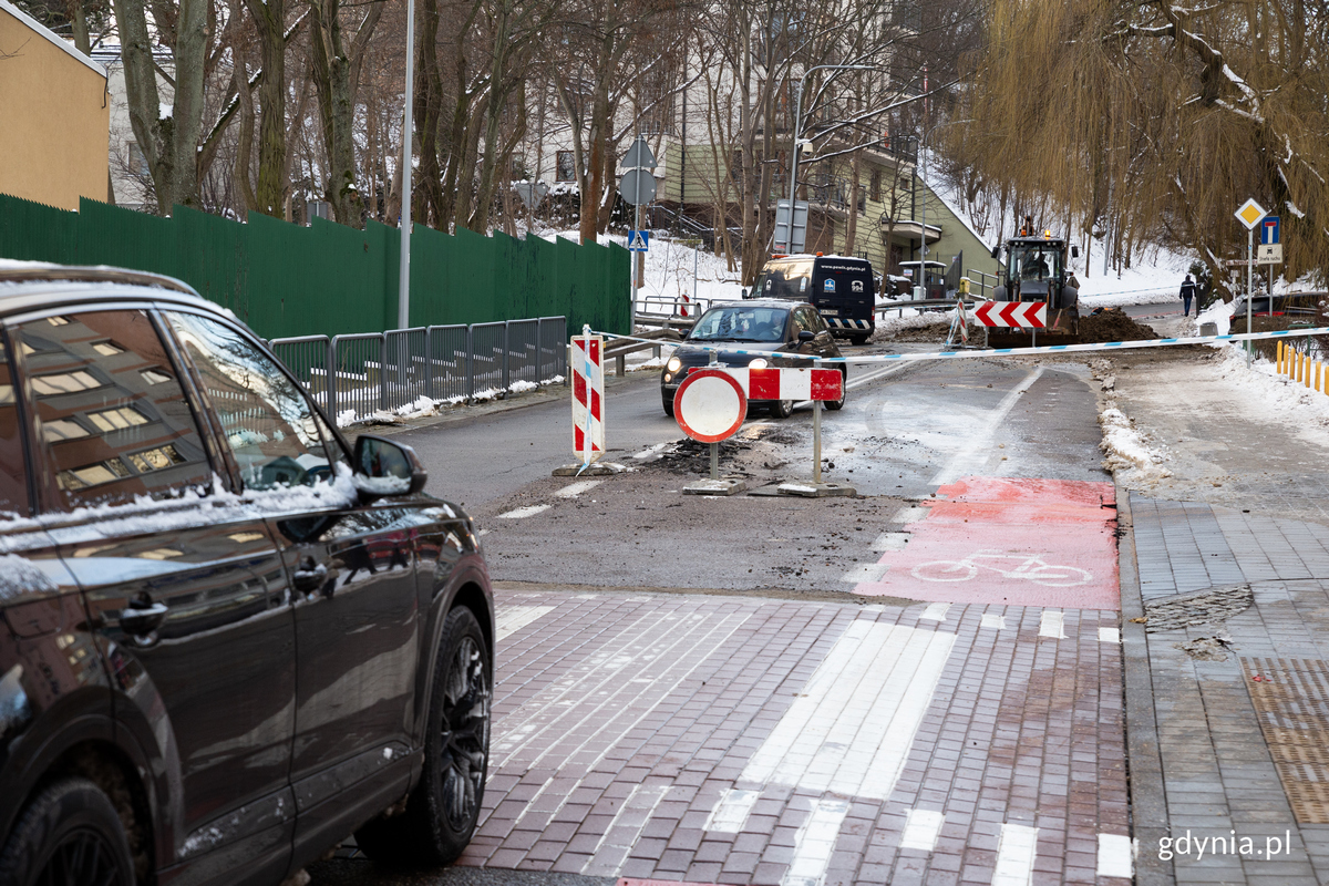 Samochody mijaja się na zamknietej ulicy.