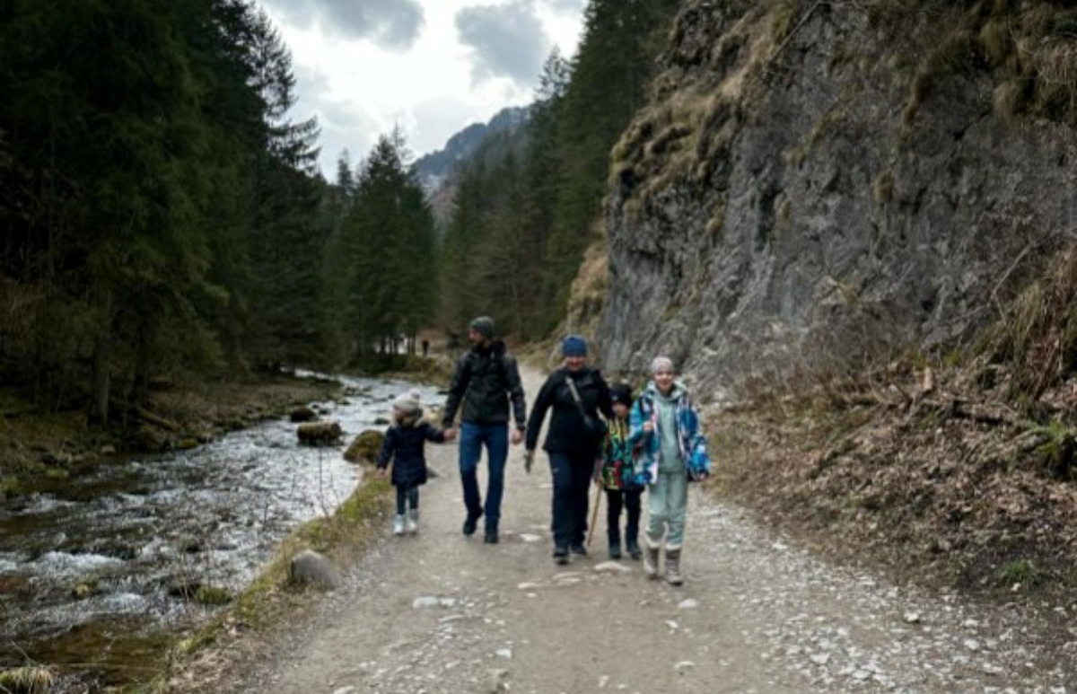 Zdjęcie przedstawia grupę ludzi w r&oacute;żny wieku podczas wycieczki g&oacute;rskiej. . 