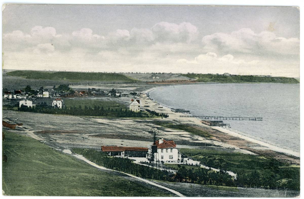 Rysunek przedstawiający zabudowania i molo na brzegu morza z początku XX w.