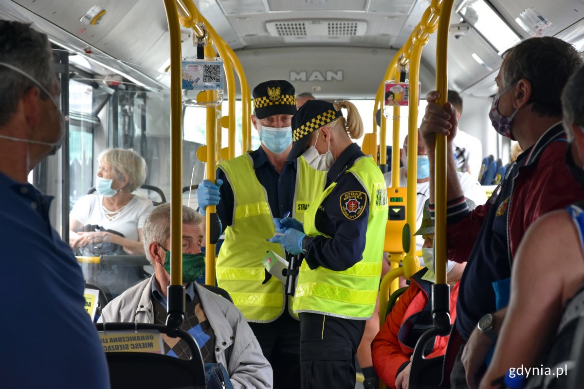 Funkcjonariusze gdyńskiej Straży Miejskiej rozdawali już maseczki pasażerom komunikacji miejskiej, fot. Madgalena Czernek
