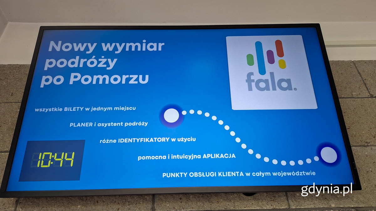 Wnętrze pomieszczenia, ekran, wyświetla się niebieska plansza promocyjna systemu FALA