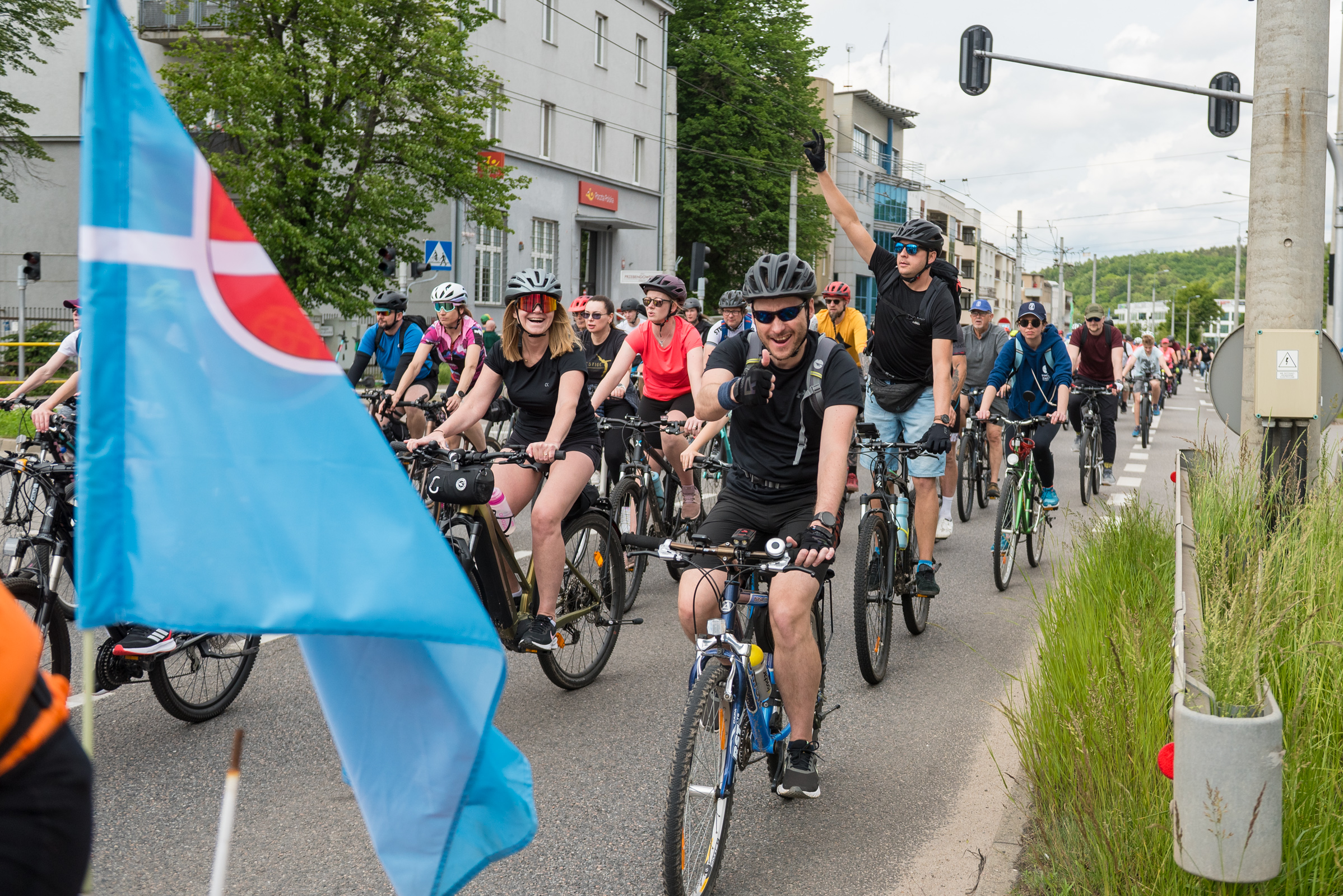 Ulica w Gdyni, tłum rowerzyst&oacute;w na ulicy, widoczna flaga Gdyni na rowerze