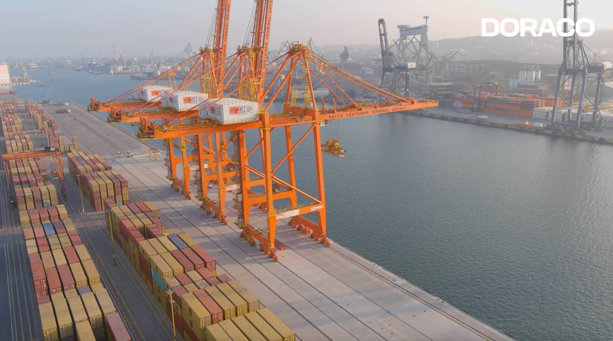 Kontenery i dźwigi na nabrzeżu widziane od boku i z g&oacute;ry