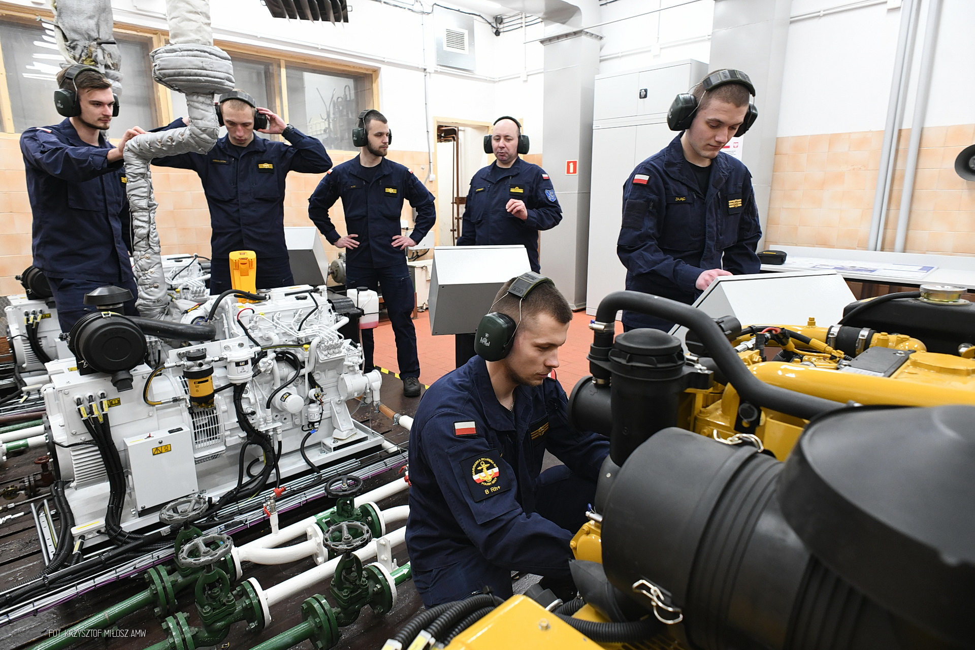 Grupa student&oacute;w w pracowni AMW, specjalistyczna aparatura, słuchawki na głowach