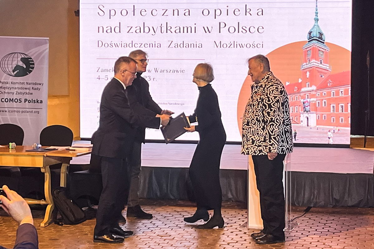 Dwie osoby odbieraja nagrody od dw&oacute;ch os&oacute;b.