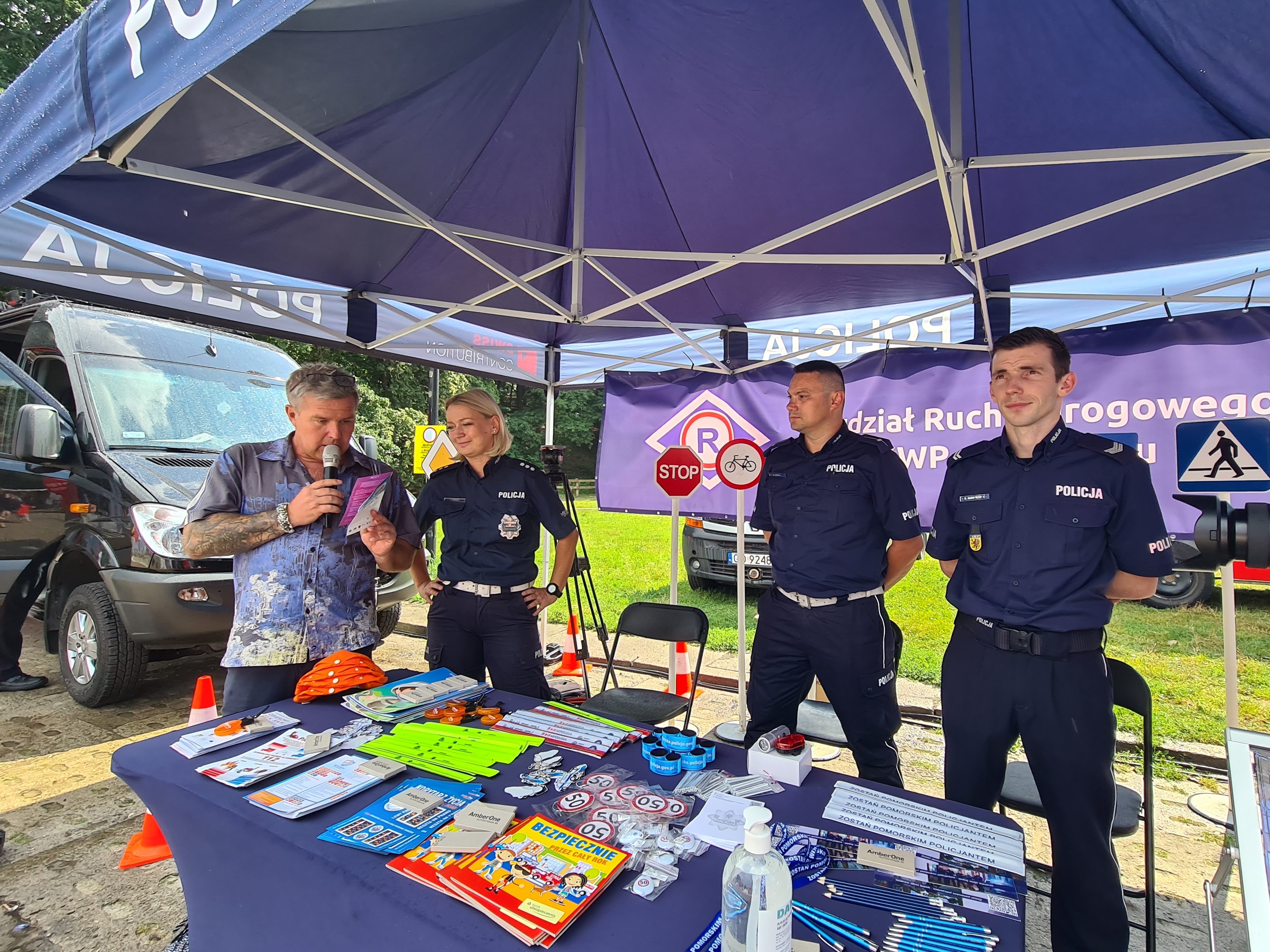 Wydział Ruchu Drogowego Komendy Wojew&oacute;dzkiej Policji w Gdańsku jak co roku stworzył specjalną strefę edukacyjną dla młodzieży i dorosłych. Uczestnikom wydarzenia zaprezentował ją Kuba Bielak (pierwszy z lewej). Obok niego pomorscy policjanci // fot. materiały prasowe