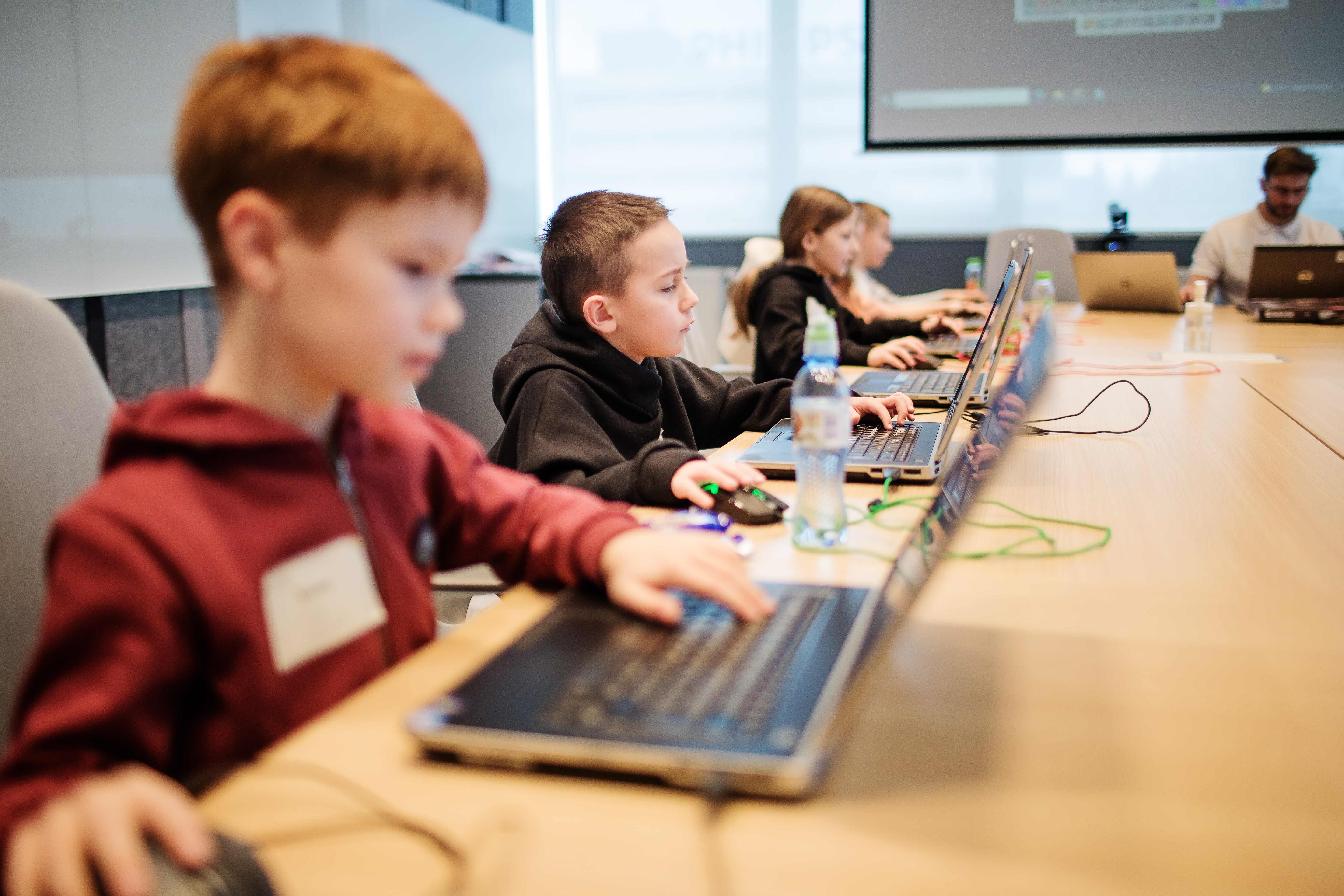 Dzieci przy laptopach podczas warsztat&oacute;w Koduj z Gigantami 