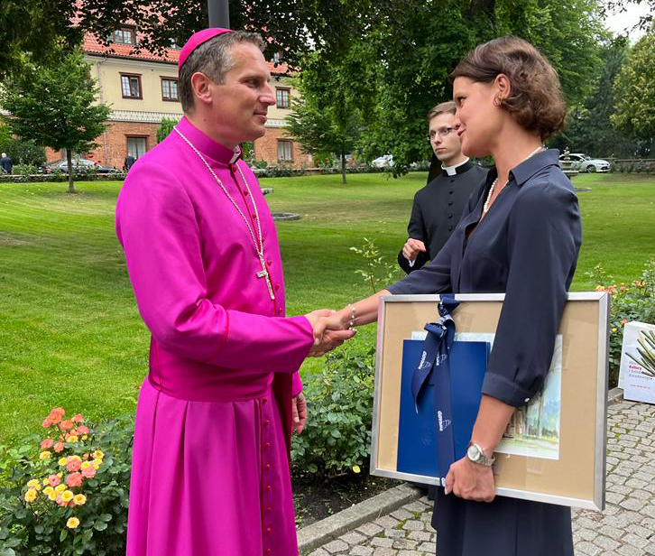 Biskup Piotr przyjmuje prezent od Katarzyny Gruszeckiej-Spychały, wiceprezydent Gdyni ds. gospodarki