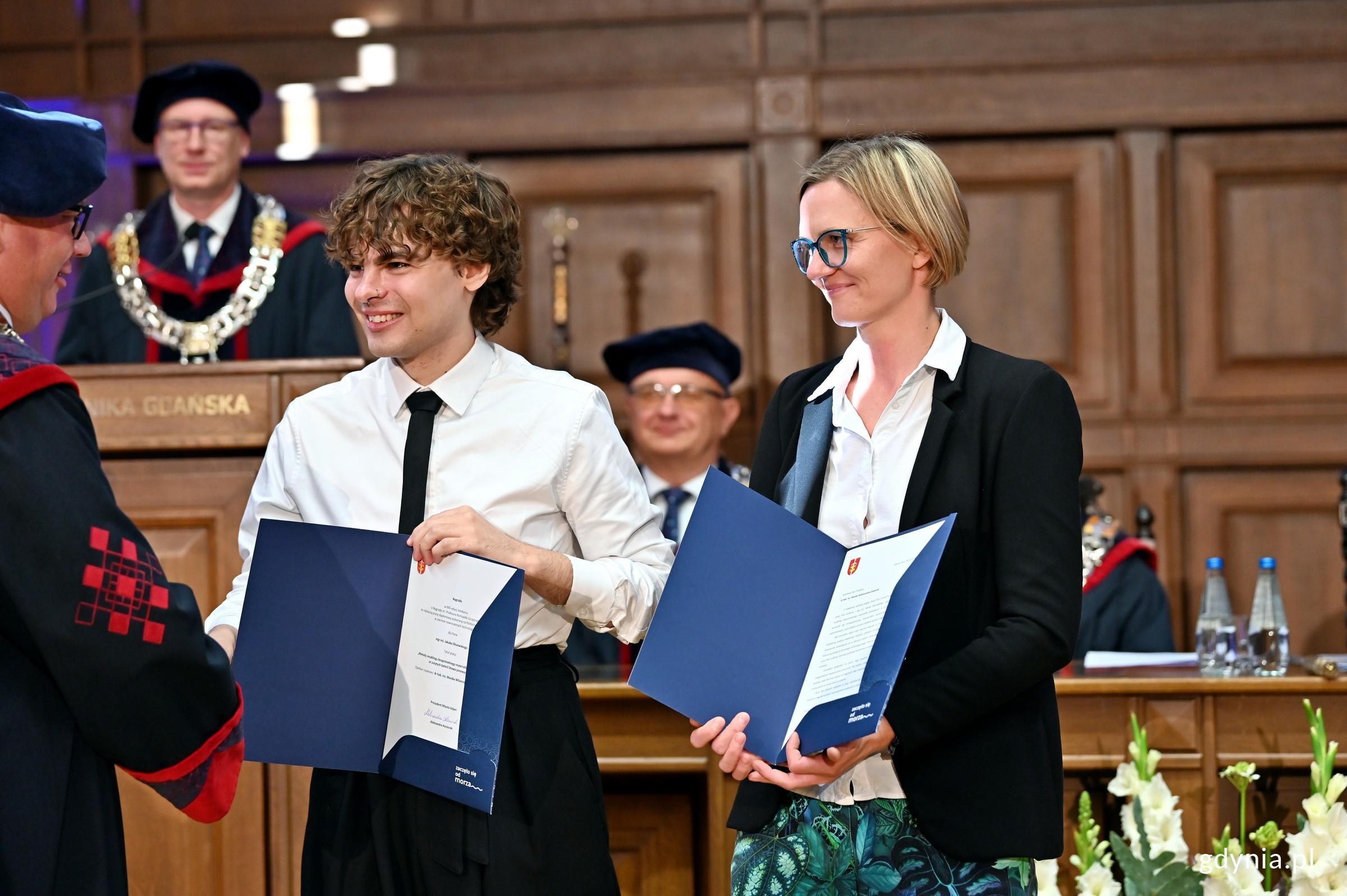 Mgr inż. Jakub Olszewski &ndash; laureat Nagrody im. prof. Romualda Szczęsnego wraz z dr hab. inż. Moniką Wilamowską-Zawłocką przyjmujący gratulacje od prof. dr hab. inż. Krzysztofa Wildego &ndash; rektora Politechniki Gdańskiej (fot. Magdalena Czernek)