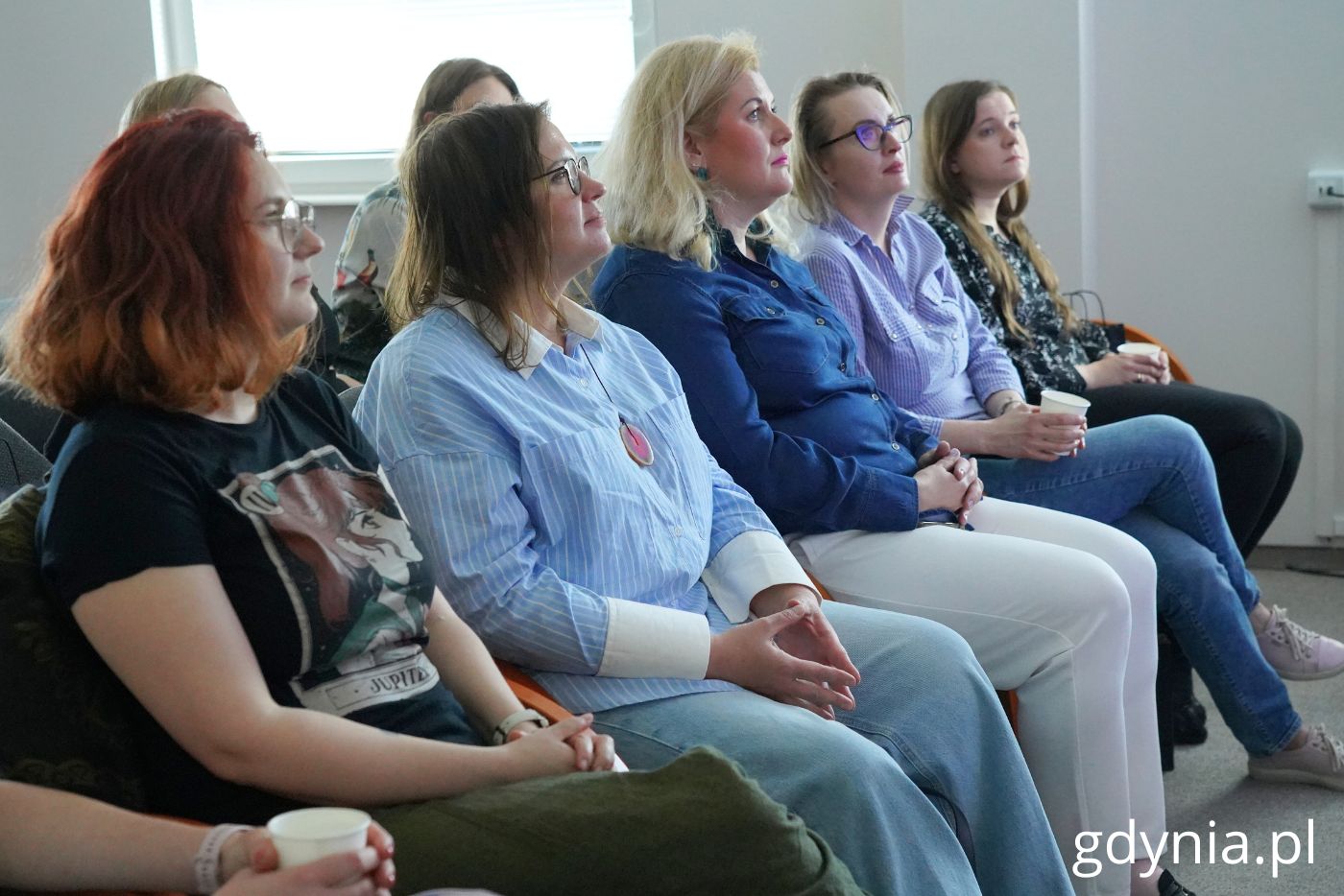 Siedzące kobiety podczas prelekcji w Powiatowym Urzędzie Pracy.