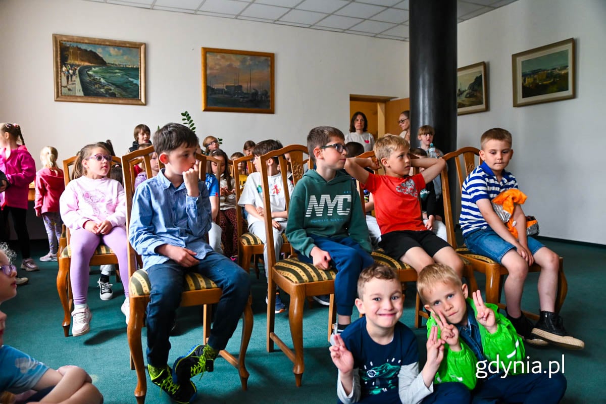 Uczniowie klasy 1a i 1b ze SP 35 w Gdynia siedzą na krzesłach w Sali Ślub&oacute;w Urzędu Stany Cywilnego w Gdyni.