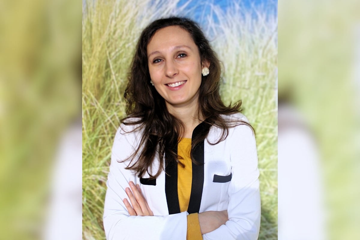 Paulina Jakubowicz stoi z założonymi rękami w biało-granatowej marynarce