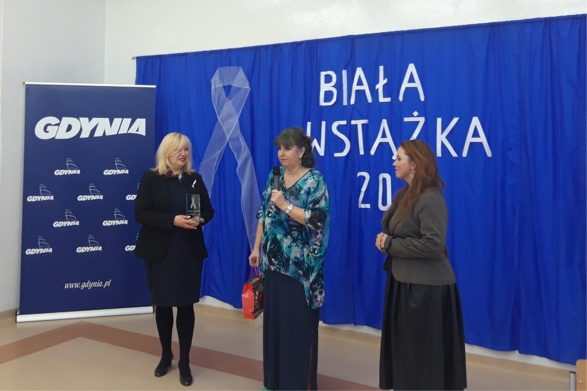 kobieta w jasnych włosach odbiera nagrodę