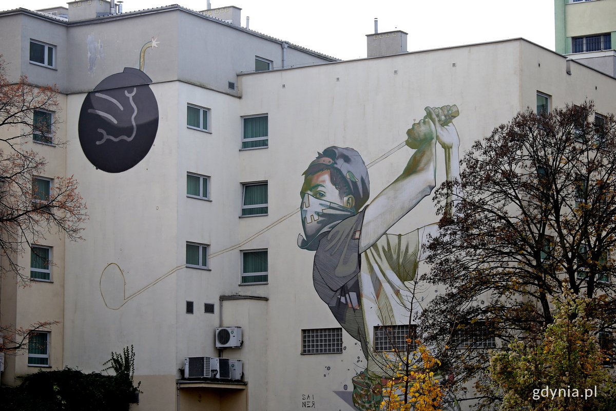 Ściany budynk&oacute;w w Śr&oacute;dmieściu, mural z golfistą