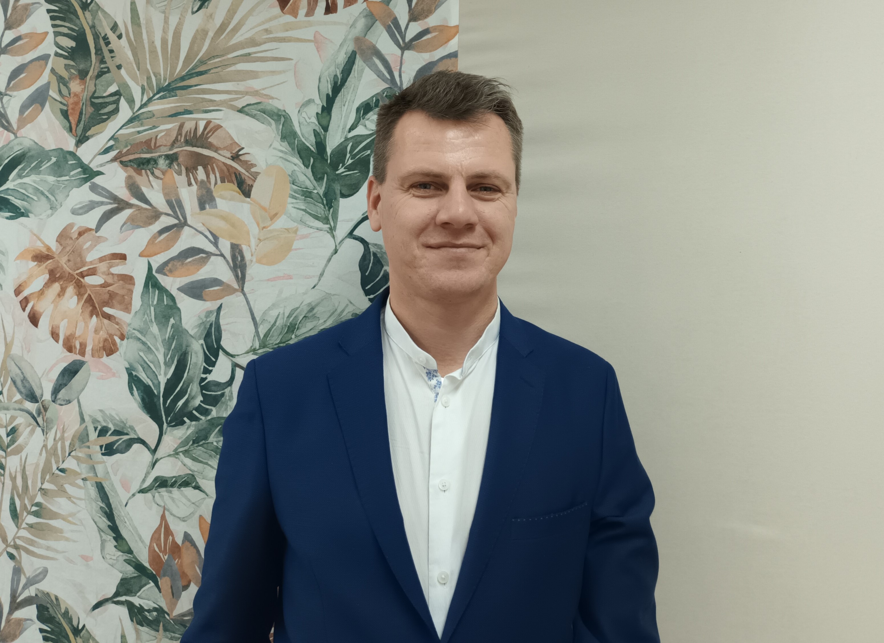 Mężczyzna pozujący na tle ściany 