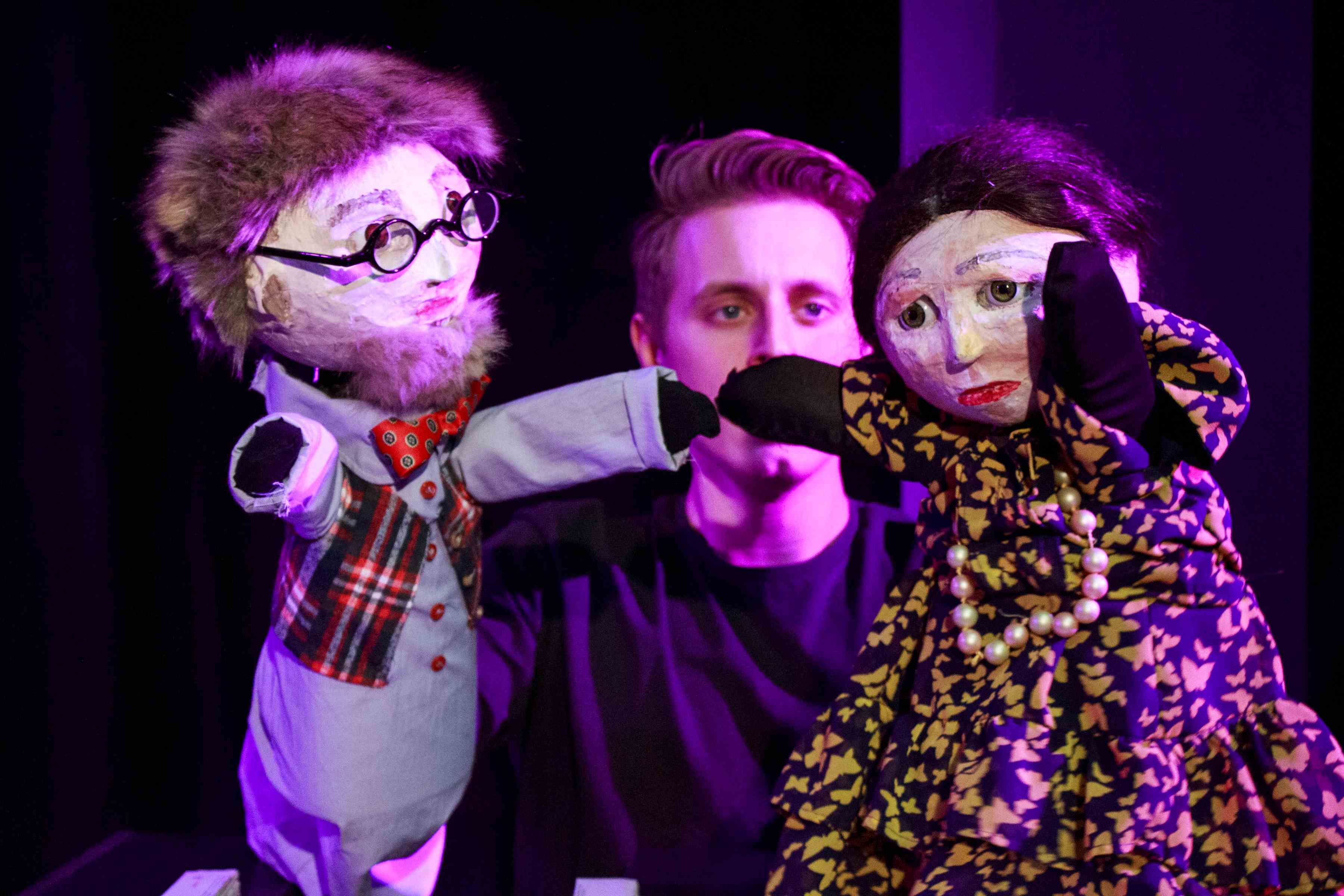 Spektakl &bdquo;Zuchwała historia z zakurzonej p&oacute;łki&rdquo;. Aktor trzyma w rękach dwie kukiełki: mężczyznę i kobietę