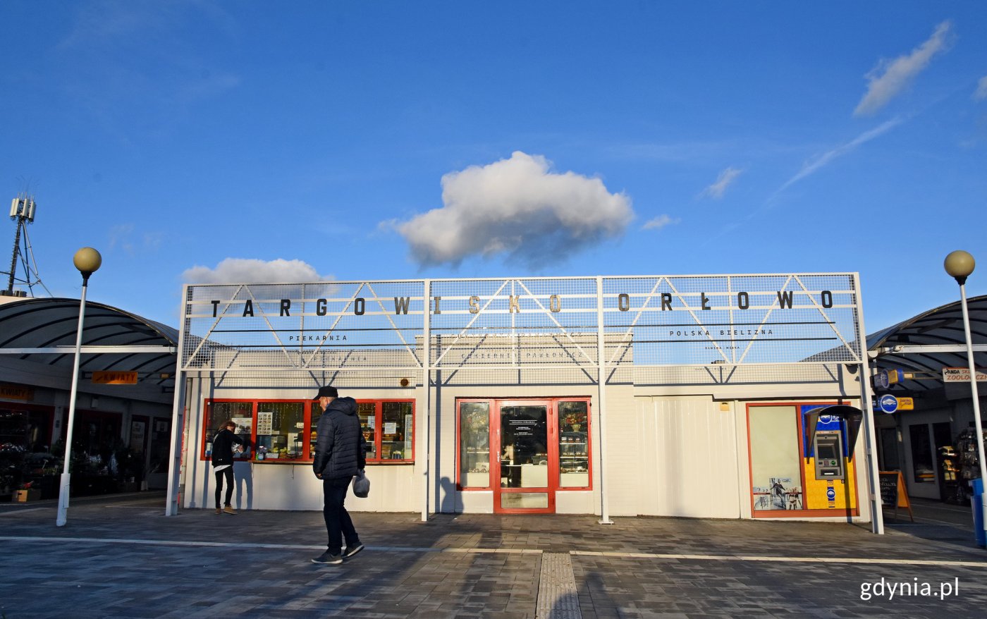 Targowisko w Orłowie, elewacja, ludzie, szyld, słoneczny dzień