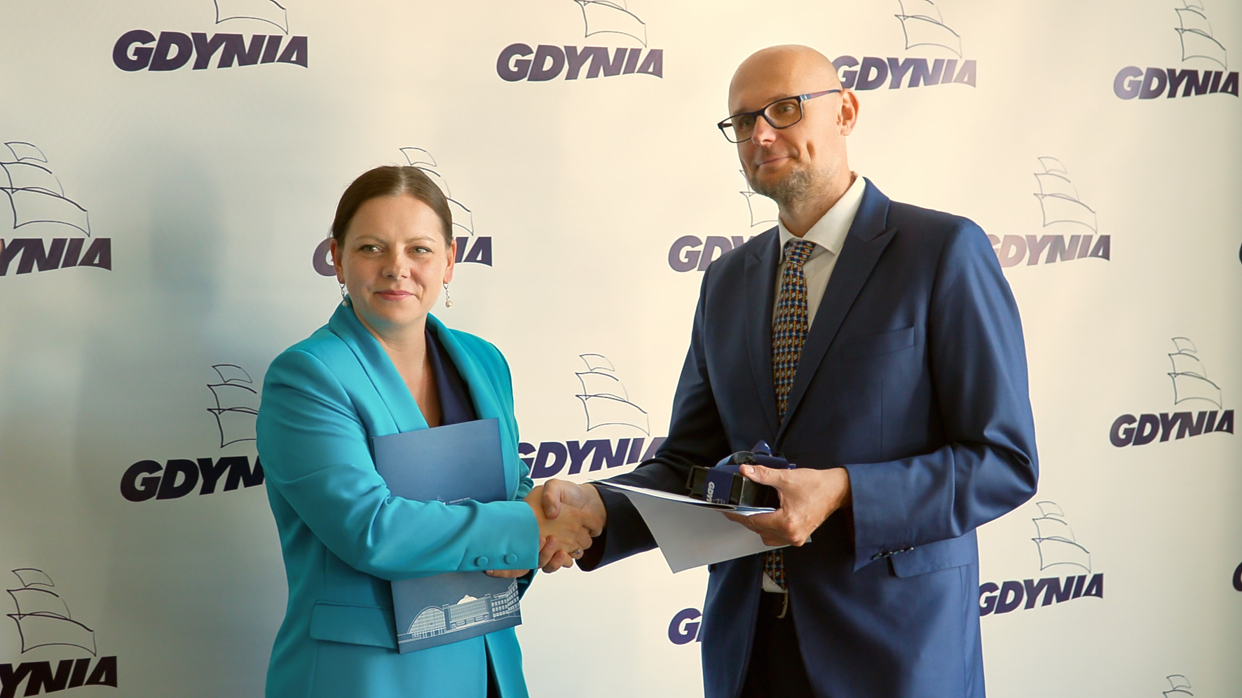 na zdjęciu kobieta i mężczyzna uśmiechają się do fotografa