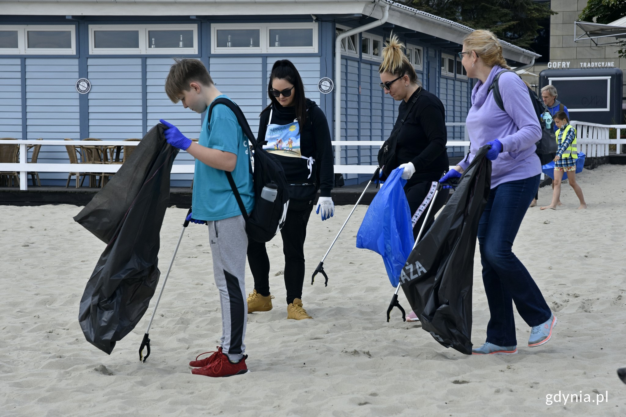 Wolontariusze z całej Polski czyścili gdyńską plażę w ramach akcji &bdquo;Bałtycka Odyseja&rdquo;. W rękach mają worki na śmieci i chwytaki // fot. Magdalena Czernek