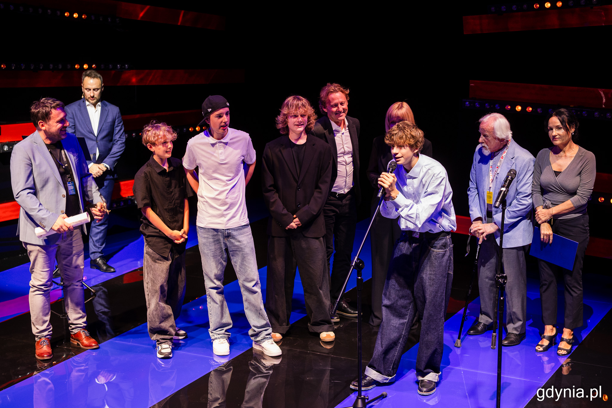 Scena Nowa, Młoda Gala, grupa os&oacute;b na scenie, jeden z kilkorga nastolatk&oacute;w przemawia przez mikrofon