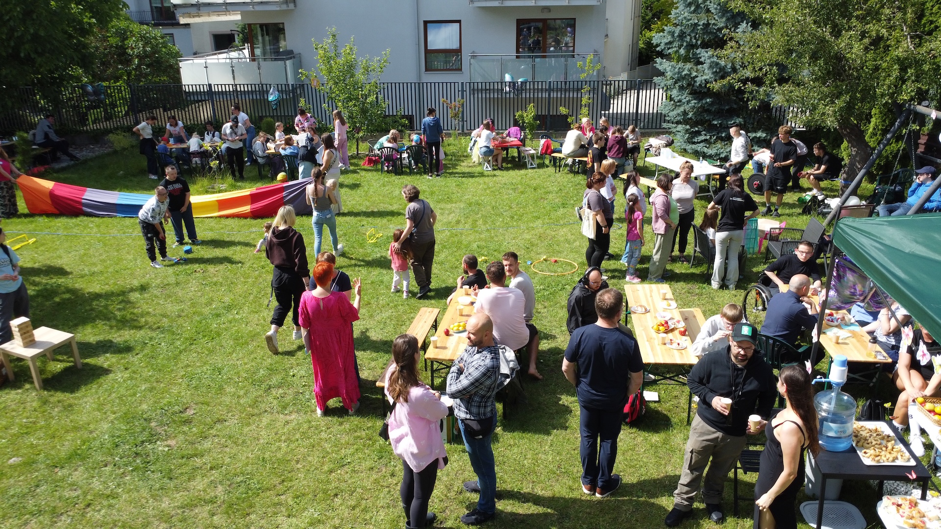 Zdjęcie z g&oacute;ry. Duża grupa ludzi w r&oacute;żnym wieku na pikniku