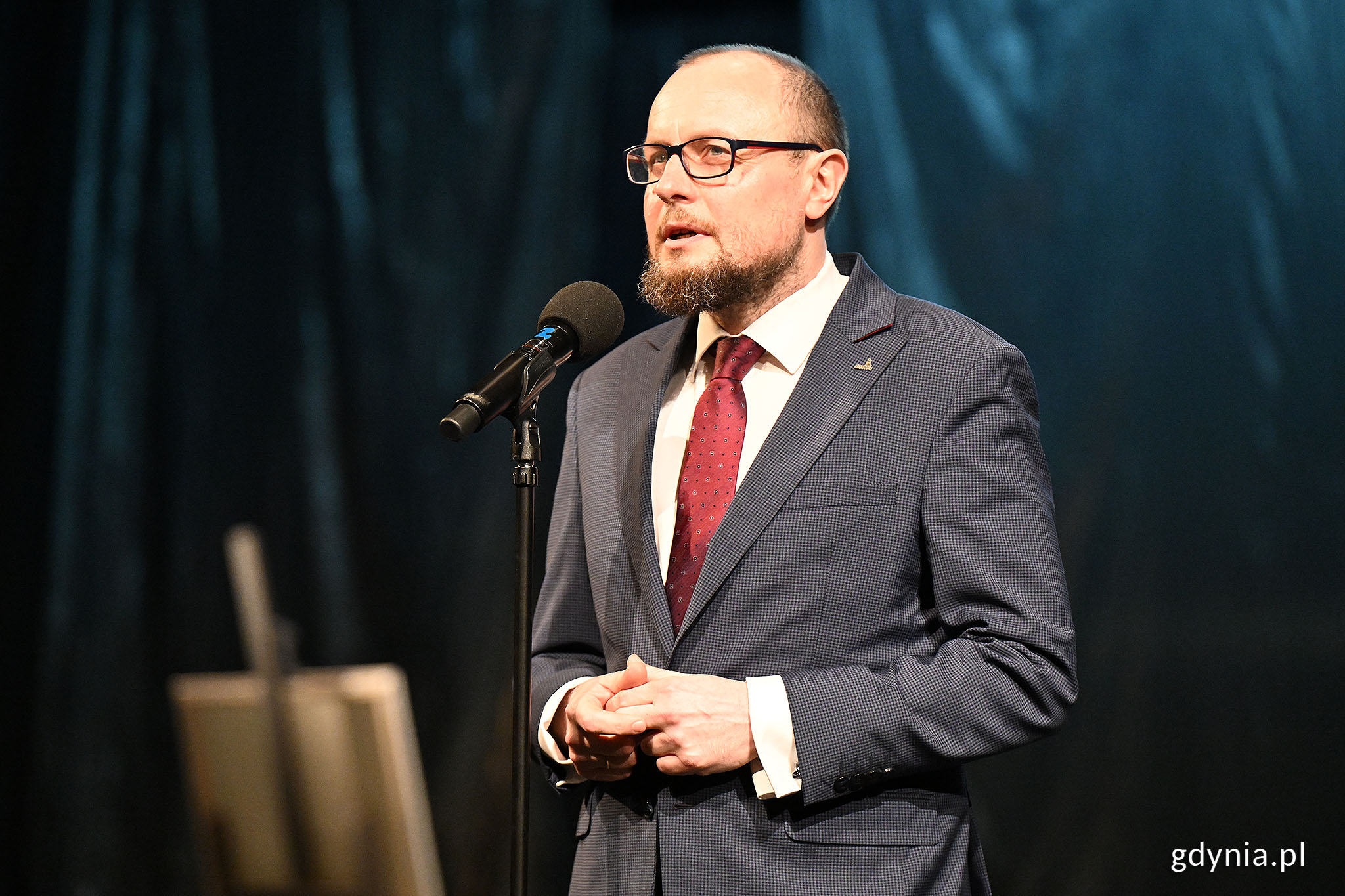 Mariusz Bzdęga - dyrektor zarządzający ds. kultury i aktywności mieszkańc&oacute;w w garniturze i okularach podczas gali z okazji Międzynarodowego Dnia Teatru (fot. Michał Puszczewicz)