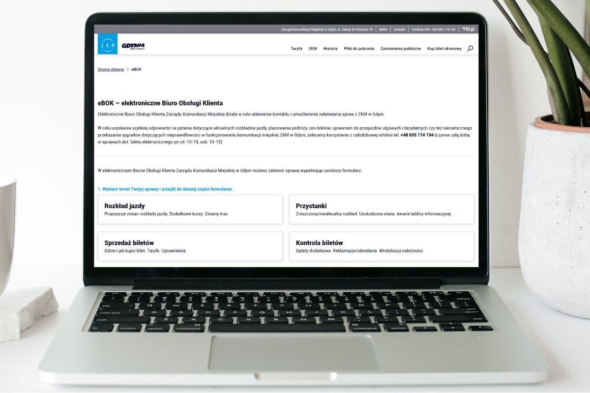 Wizualizacja laptopa na biurku, na monitorze wyświetla się strona internetowa eBOK w ZKM Gdynia