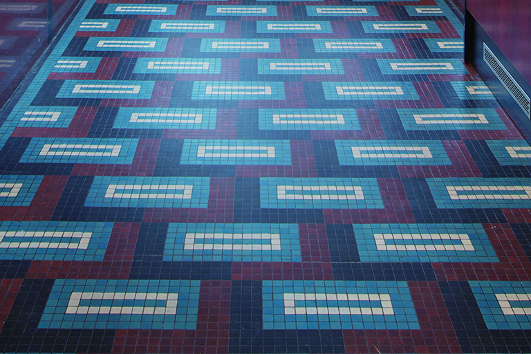 Posadzka w holu kamienicy przy ul. 10 Lutego&nbsp;5, geometryczny motyw dekoracyjny skomponowany z wielobarwnych irysk&oacute;w