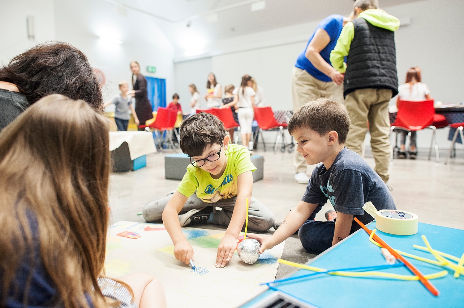 Dzieci podczas warsztat&oacute;w w Muzeum Emigracji siedzą na podłodze i rysują na kartkach