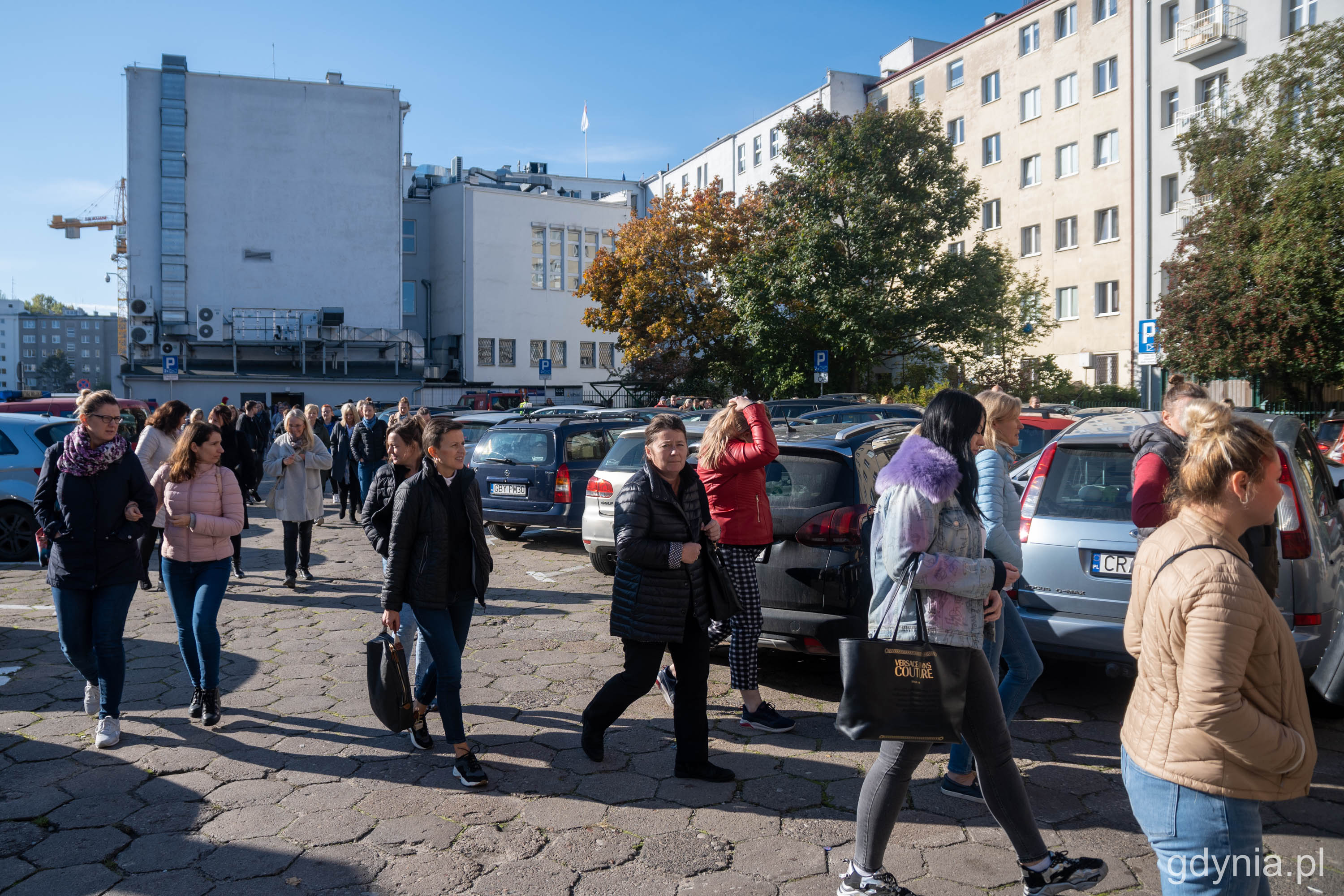 Pracownicy Urzędu Miasta Gdyni wychodzący z budynku i gromadzący się w punkcie zbi&oacute;rki przy ul. Bema // fot. Paweł Kukla