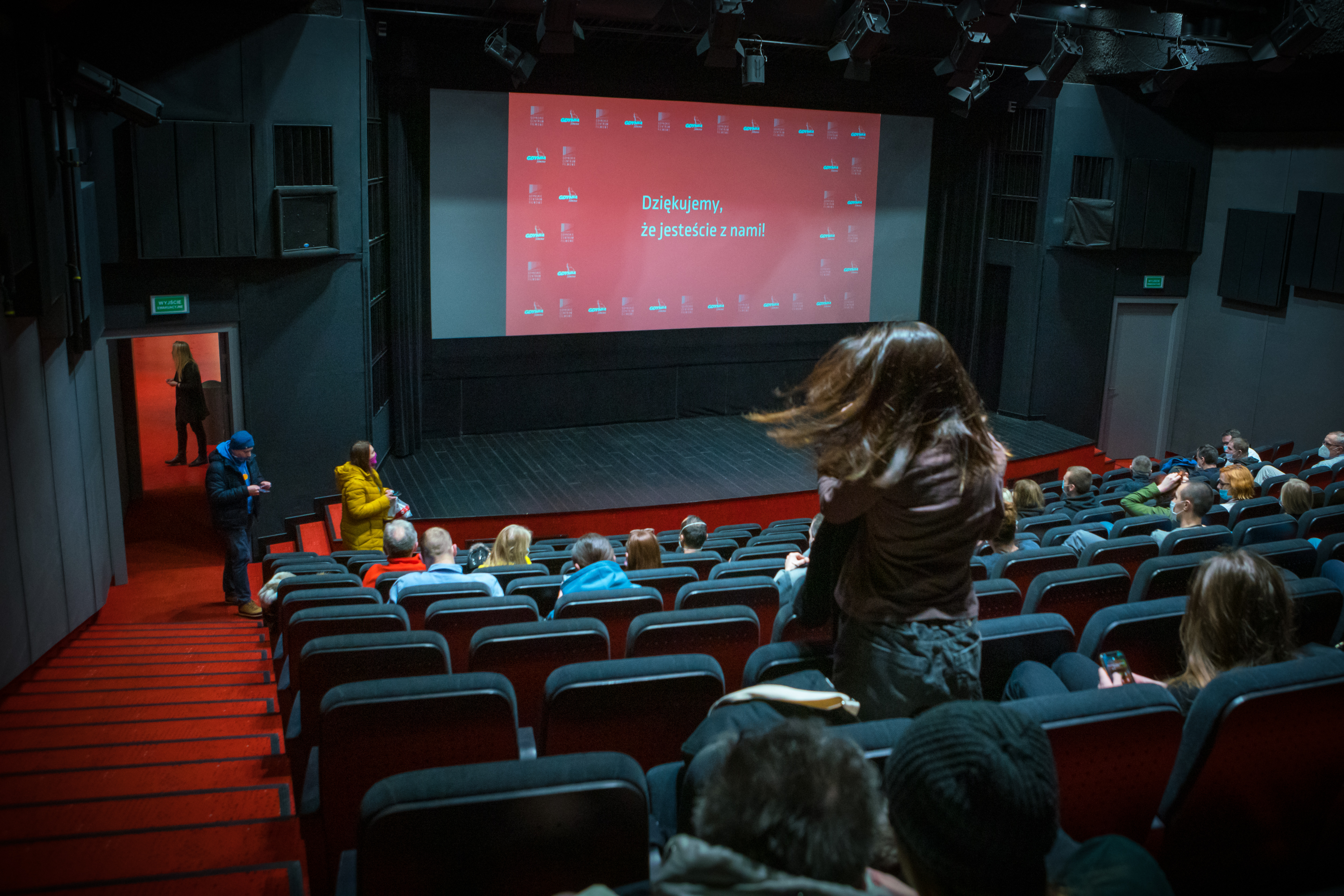 Sala kinowa w Gdyńskim Centrum Filmowym, na ekranie wyświetla się biały napis na czerwonym tle "Dziękujemy, że jesteście z nami!". Fot. Anna Rezulak / KFP