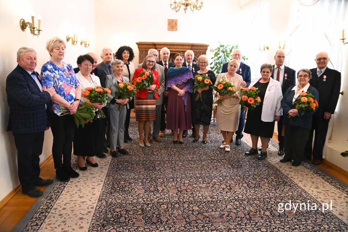 Grupa senior&oacute;w stojąca w rzędzie z prezydent Gdyni Aleksandrą Kosiorek