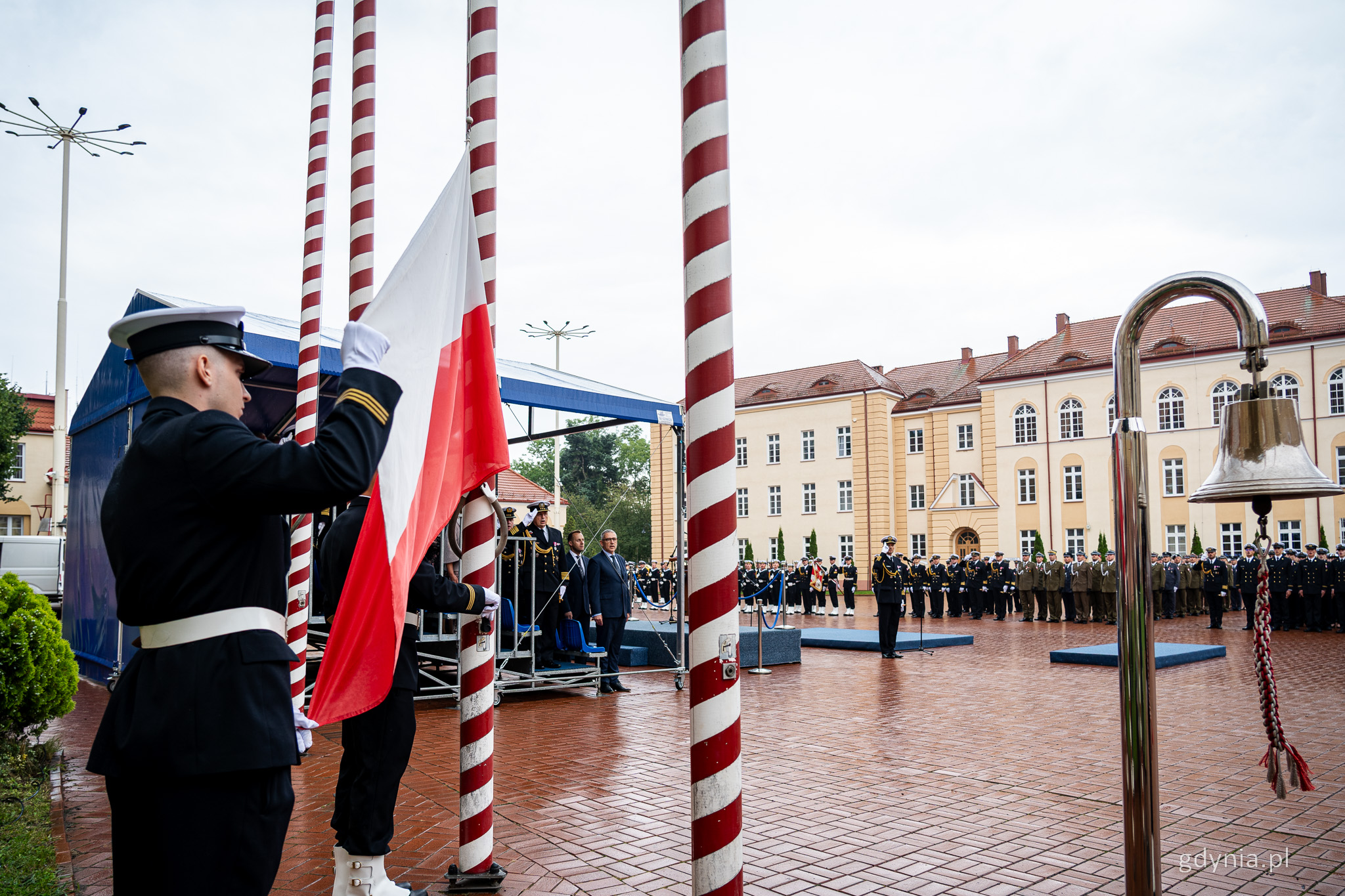 Plac apelowy w AMW, grupa żołnierzy w mundurach, wciąganie flagi Polski na maszt