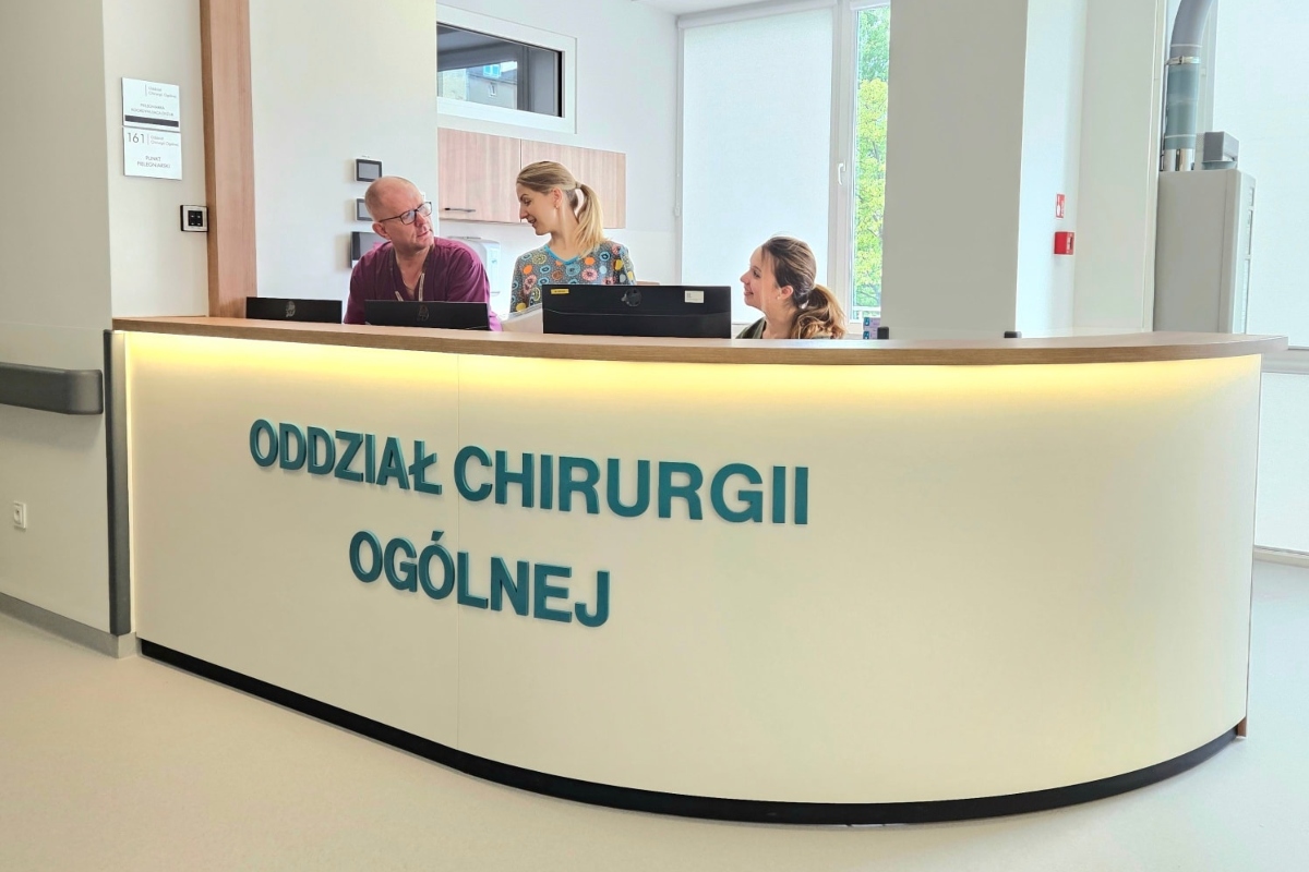 Oddział Chirurgii Og&oacute;lnej Szpitala św. Wincentego a Paulo po modernizacji. Za ladą - część personelu oddziału w kitlach (fot. Szpitale Pomorskie)