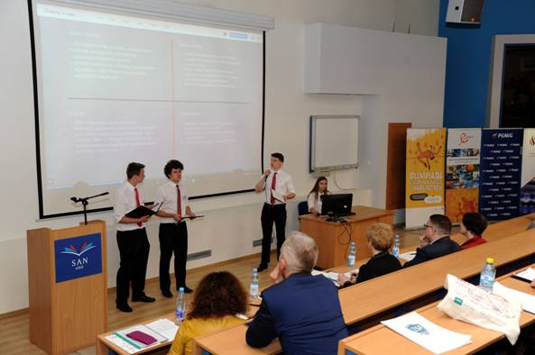 Prezentacja w wykonaniu laureat&oacute;w pierwszego m-ca w finale II Olimpiady Wiedzy o Biznesie i Innowacjach. Piotr Stomp&oacute;r stoi przed ekranem jako drugi od lewej, fot. mat. prasowe     